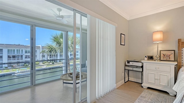 entryway featuring a ceiling fan, a wealth of natural light, a water view, and crown molding