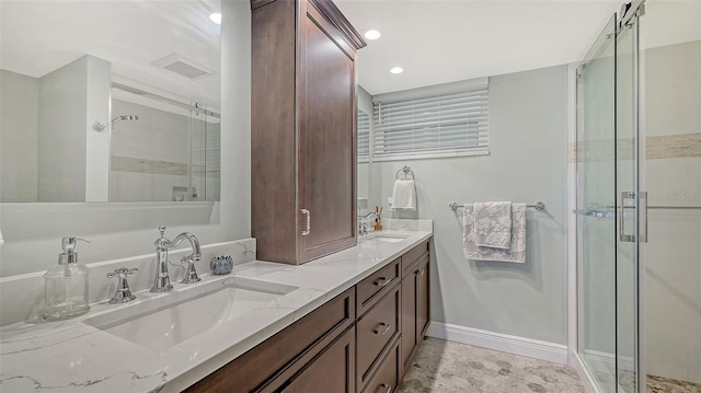 full bathroom featuring double vanity, visible vents, a stall shower, and a sink