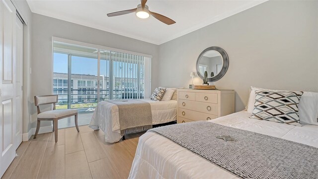bedroom featuring a ceiling fan, light wood-style floors, a closet, crown molding, and baseboards