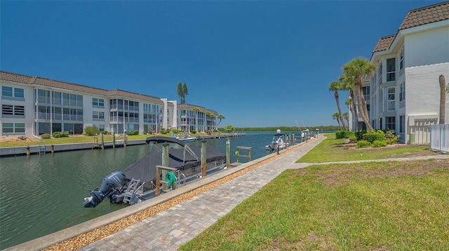 dock area with a yard and a water view