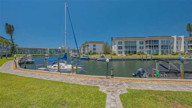 exterior space with a lawn, a boat dock, and a water view