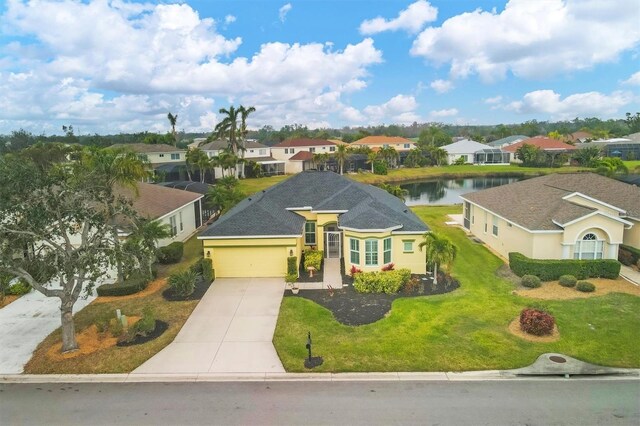 view of front of property with a water view, a garage, and a front lawn