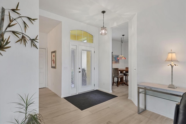 foyer with a notable chandelier and light wood-type flooring