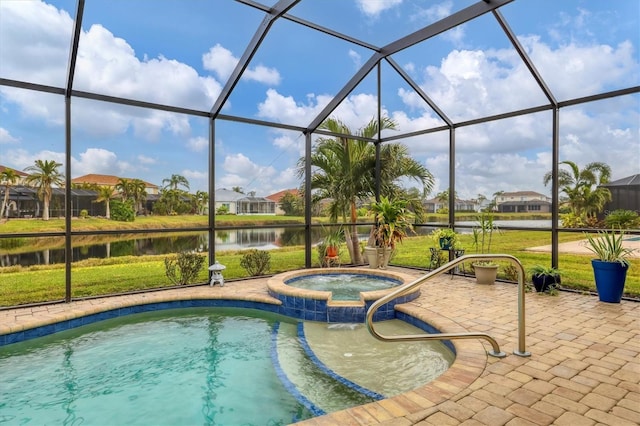 view of pool with a patio, a lawn, an in ground hot tub, glass enclosure, and a water view