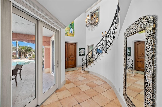 entryway with a towering ceiling, baseboards, stairs, french doors, and an inviting chandelier