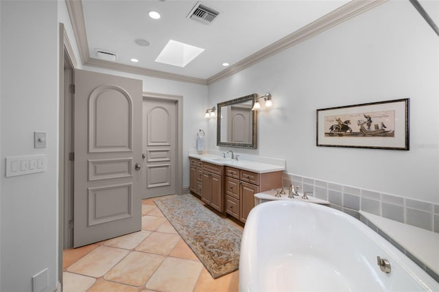 bathroom with a freestanding bath, a skylight, tile patterned flooring, and crown molding