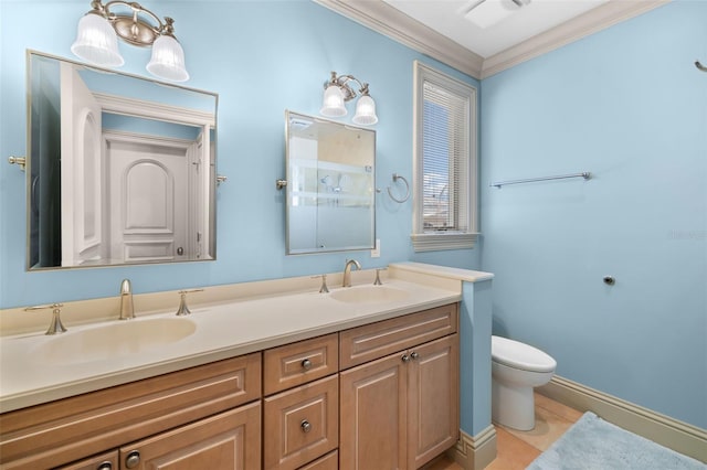 full bathroom featuring double vanity, crown molding, toilet, and a sink