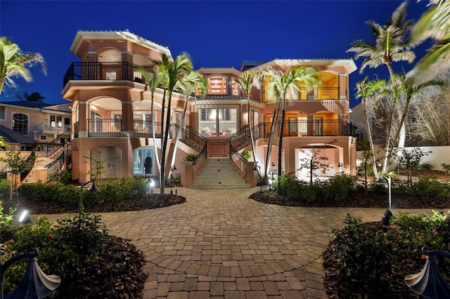 mediterranean / spanish-style house featuring stairs and stucco siding