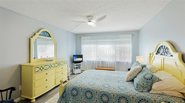 bedroom featuring a textured ceiling, ceiling fan, and wood finished floors