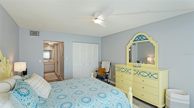 bedroom with a ceiling fan, a textured ceiling, visible vents, and a closet