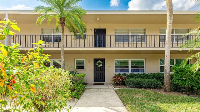 view of front of house with a balcony and stucco siding