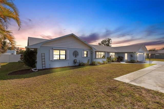 ranch-style house featuring a garage and a yard