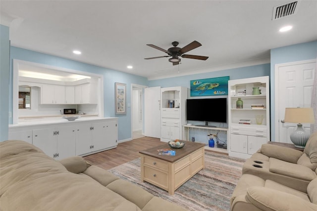 living room with light hardwood / wood-style floors and ceiling fan