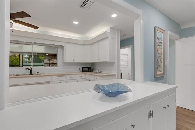 kitchen featuring white cabinetry, ceiling fan, light hardwood / wood-style floors, and sink