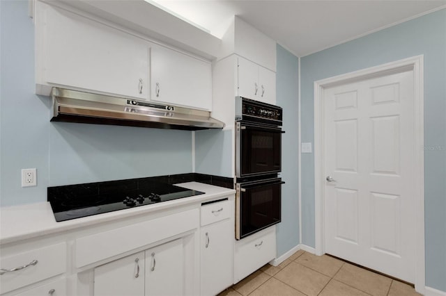 kitchen featuring white cabinetry, light tile patterned flooring, and black appliances