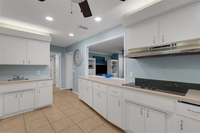 kitchen featuring sink, white cabinets, light tile patterned floors, ceiling fan, and black electric cooktop