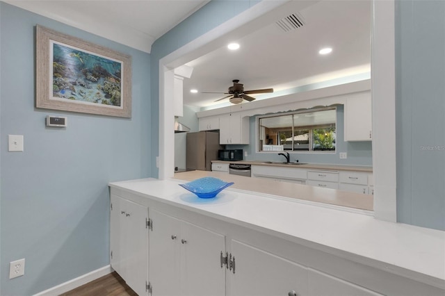 kitchen featuring appliances with stainless steel finishes, dark hardwood / wood-style floors, sink, white cabinets, and ceiling fan