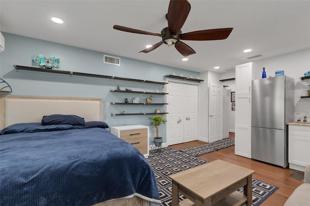 bedroom featuring ceiling fan, dark hardwood / wood-style floors, and stainless steel refrigerator