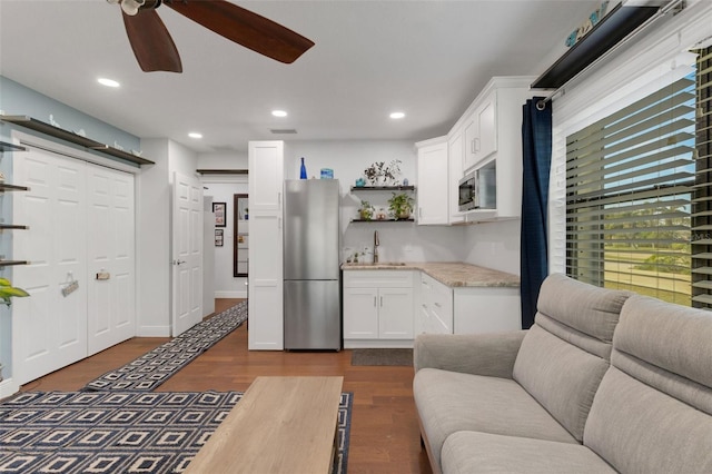 kitchen with sink, white cabinetry, dark hardwood / wood-style flooring, ceiling fan, and stainless steel appliances