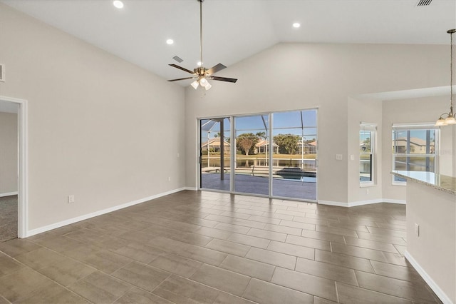 unfurnished living room featuring ceiling fan with notable chandelier and high vaulted ceiling