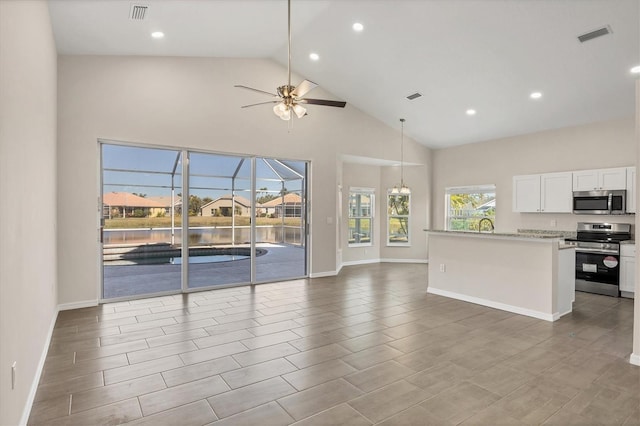 kitchen with white cabinetry, high vaulted ceiling, pendant lighting, ceiling fan, and stainless steel appliances