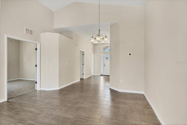 unfurnished room featuring high vaulted ceiling and a chandelier