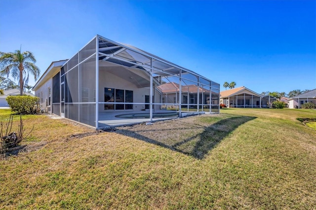 back of property featuring a patio, a yard, and glass enclosure