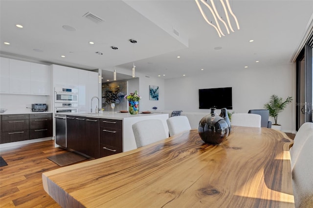 dining room with sink and light wood-type flooring