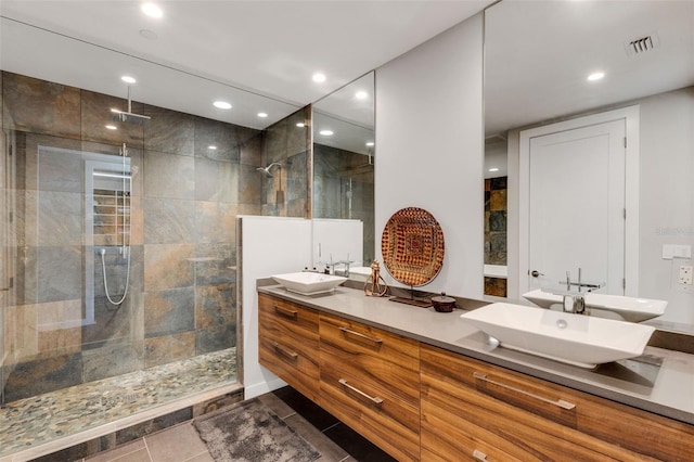 bathroom with vanity, tiled shower, and tile patterned floors