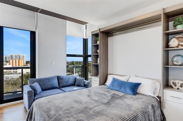 bedroom with light hardwood / wood-style floors and multiple windows