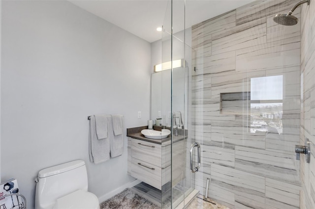 bathroom with a shower with door, vanity, and toilet