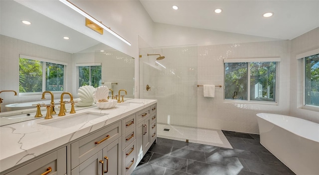 bathroom with vanity, vaulted ceiling, independent shower and bath, and plenty of natural light