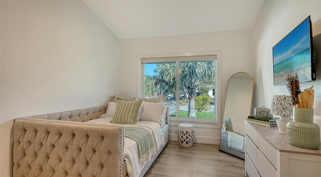 bedroom with lofted ceiling and light wood-type flooring