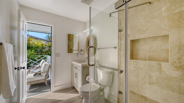 bathroom featuring hardwood / wood-style flooring, vanity, an enclosed shower, and toilet