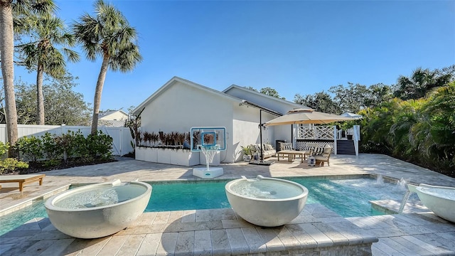 view of swimming pool featuring pool water feature, a jacuzzi, and a patio