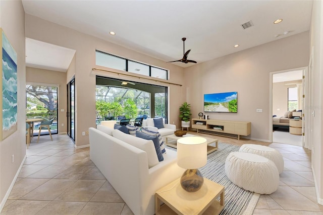 living room with a healthy amount of sunlight, light tile patterned floors, and ceiling fan