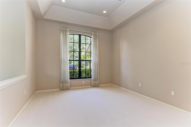 unfurnished room with carpet and a tray ceiling