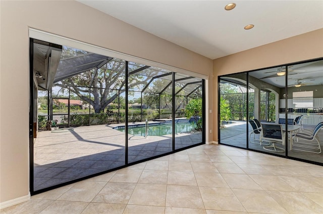 doorway with ceiling fan and light tile patterned floors