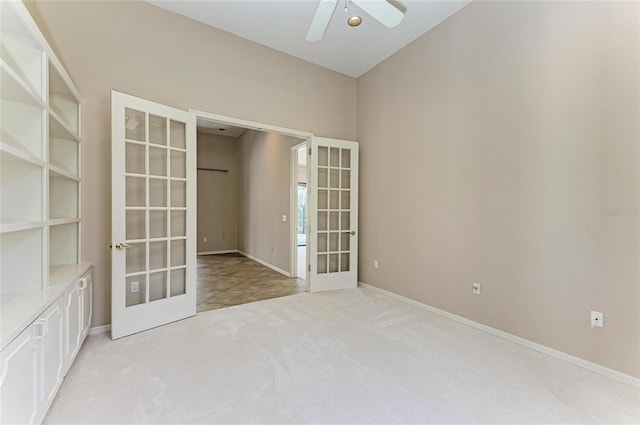 spare room with light colored carpet, ceiling fan, and french doors