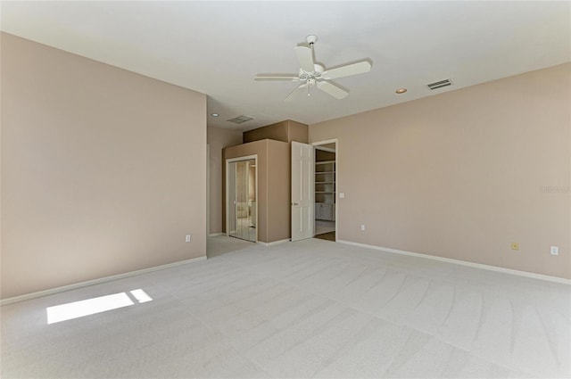 unfurnished room with ceiling fan and light carpet