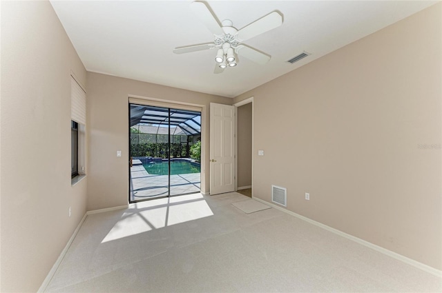 spare room featuring light colored carpet and ceiling fan