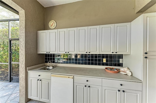 kitchen with white cabinetry, white dishwasher, and sink