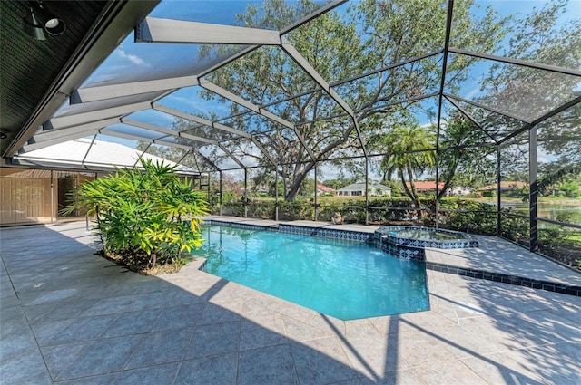 view of pool featuring an in ground hot tub, a patio area, and glass enclosure