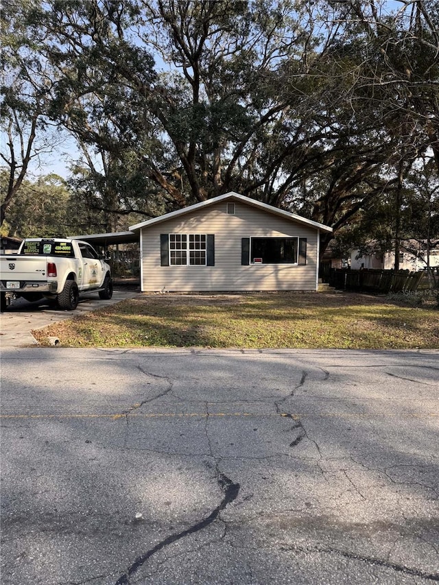 view of side of property featuring a carport and a lawn