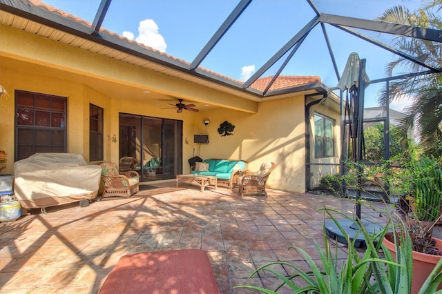 view of patio / terrace with an outdoor living space, ceiling fan, and glass enclosure