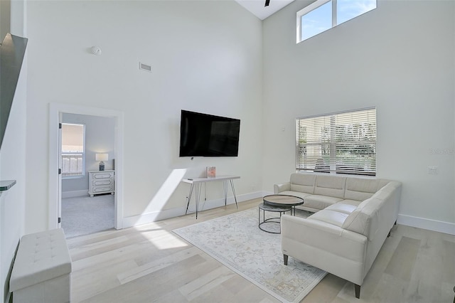 living room featuring light hardwood / wood-style floors and a high ceiling