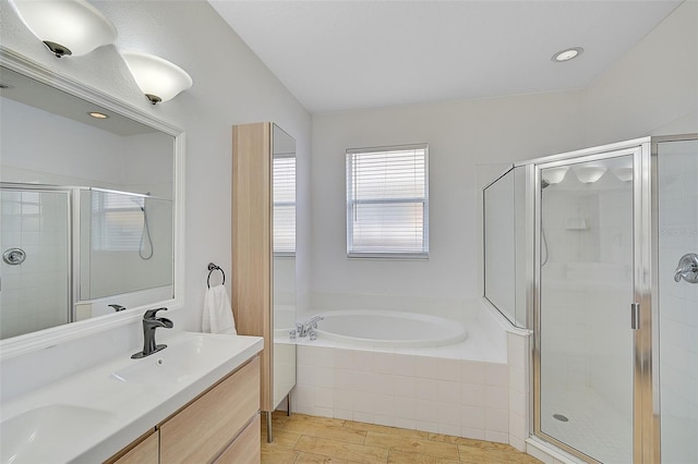 bathroom featuring vanity, hardwood / wood-style flooring, and shower with separate bathtub