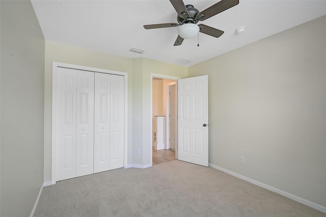 unfurnished bedroom featuring light carpet, a closet, and ceiling fan