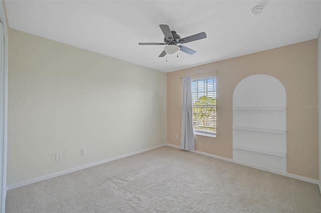 unfurnished room with ceiling fan and light carpet