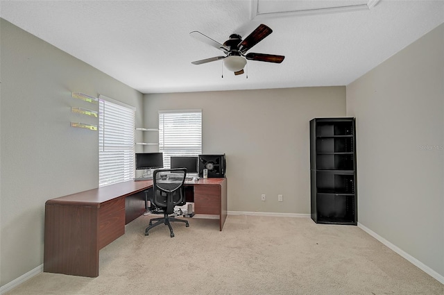 carpeted office space featuring a textured ceiling and ceiling fan